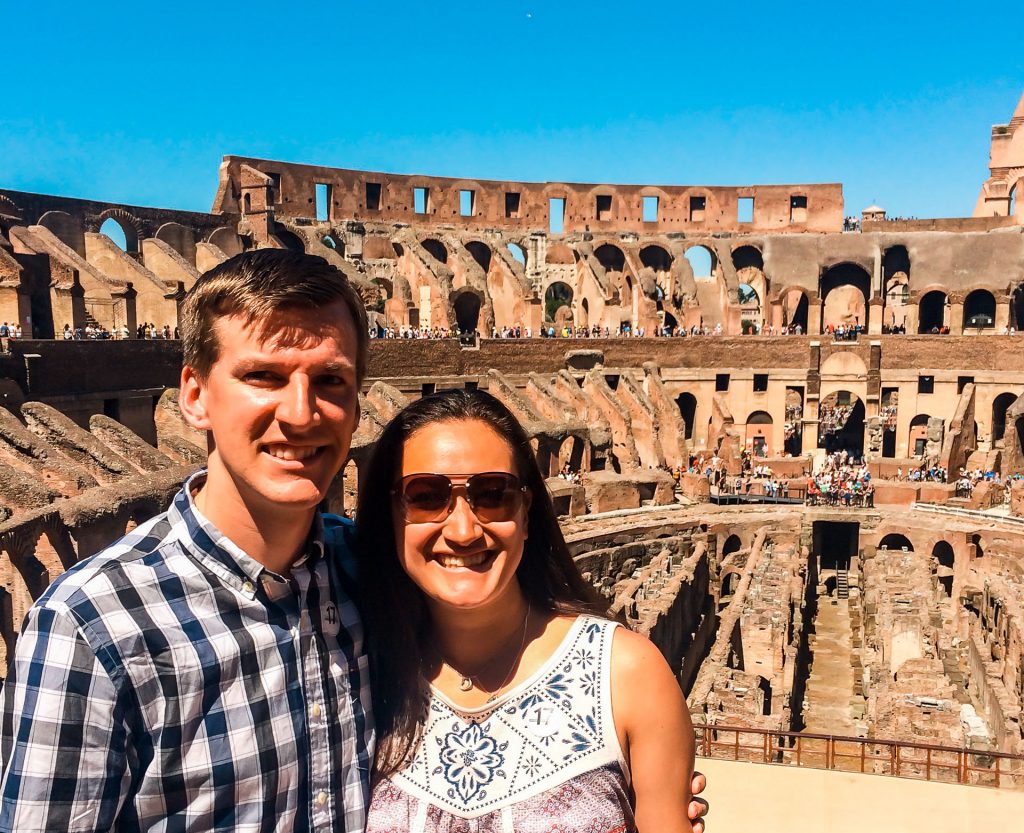A couple posing and smiling inside the Colosseum during their 2 days in Rome.