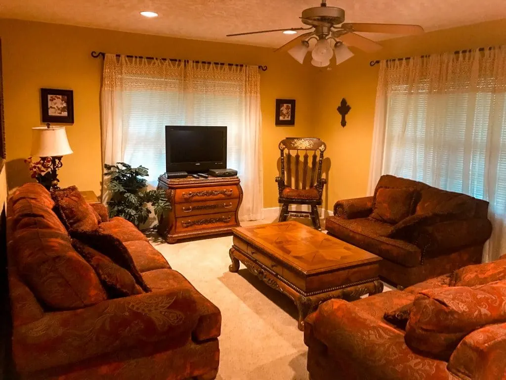 Inside a rental house in Fredericksburg, Texas of the living room with three couches, center table and TV. 