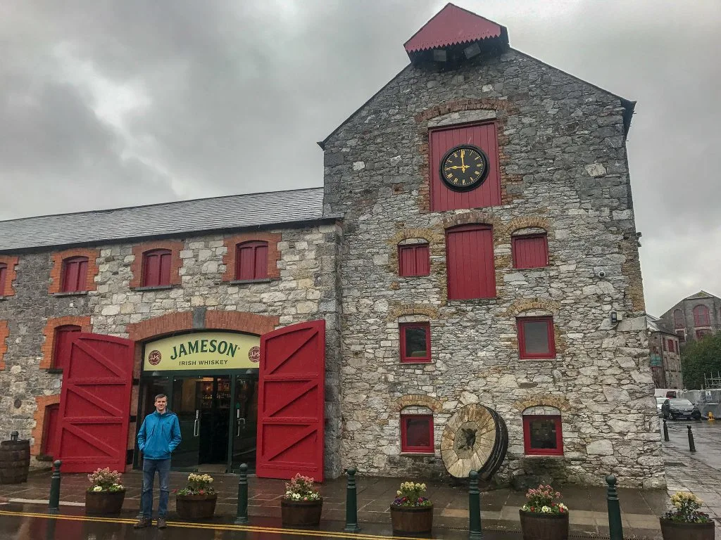 A guy standing in front of a Jameson building in Cork, Ireland - one of the best things to do during your 7 days in Ireland.