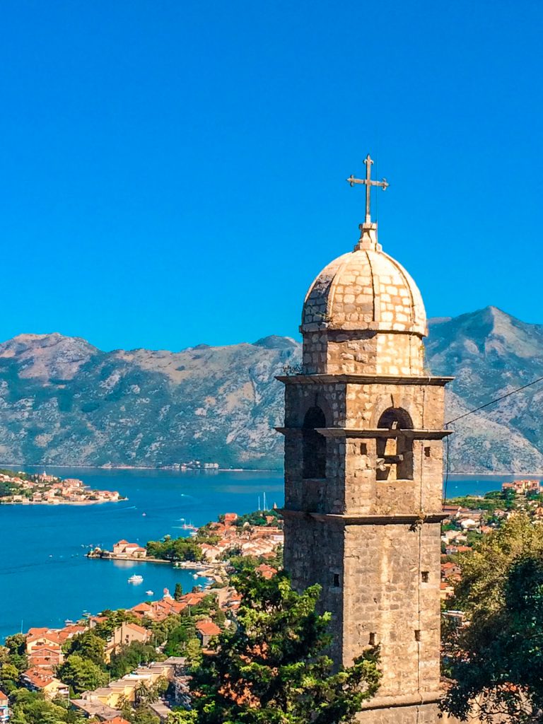 Church of Our Lady of Remedy tower with a small dome towering above the city and Bay of Kotor. 