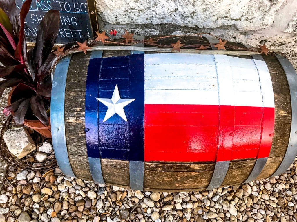 A wine barrel with the Texas flag painted on top.