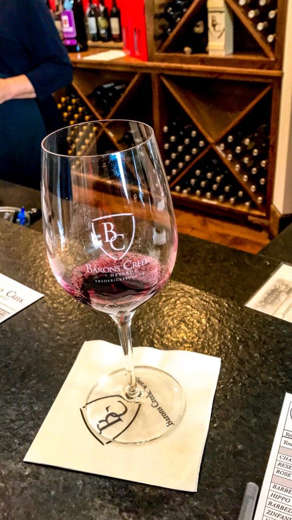 A red wine being poured into a glass for a wine tasting at Barons Creek Vineyard. 