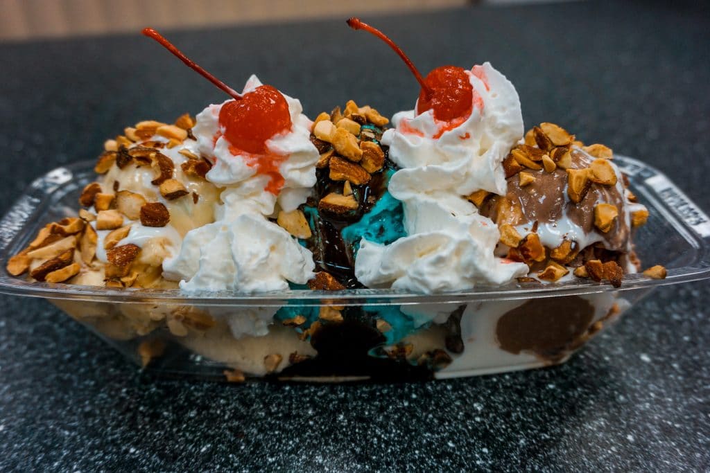 A classic ice cream sundae of three different scoops of ice cream covered in whipped cream and toasted almonds from Braum's.
