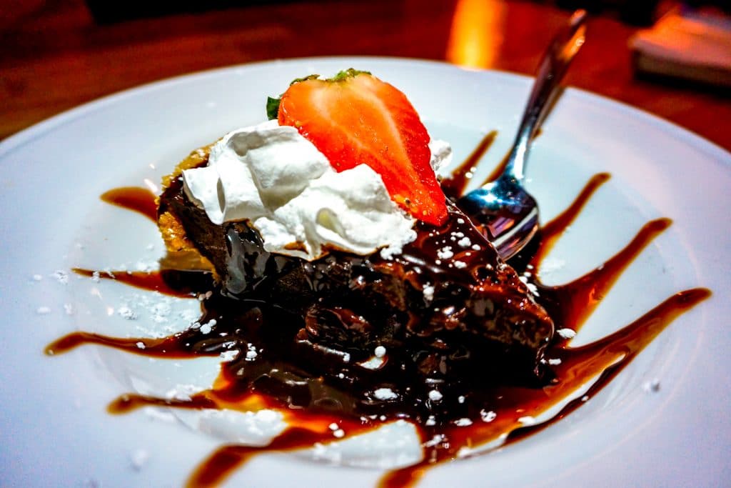 A mouthwatering plate of hot fudge pie with whipped cream and a strawberry on top from Didi's Downtown.