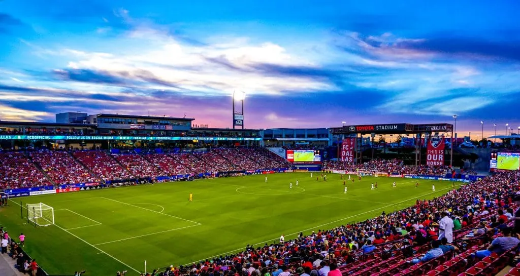 Stunning sunset photo of the FC Dallas soccer game at Toyota Stadium in Frisco with shades of deep blue and purple in the sky.