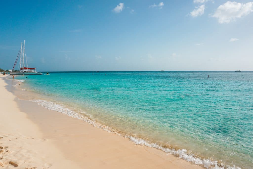 A beautiful photo of a white sand beach and turquoise water in the Grand Cayman.