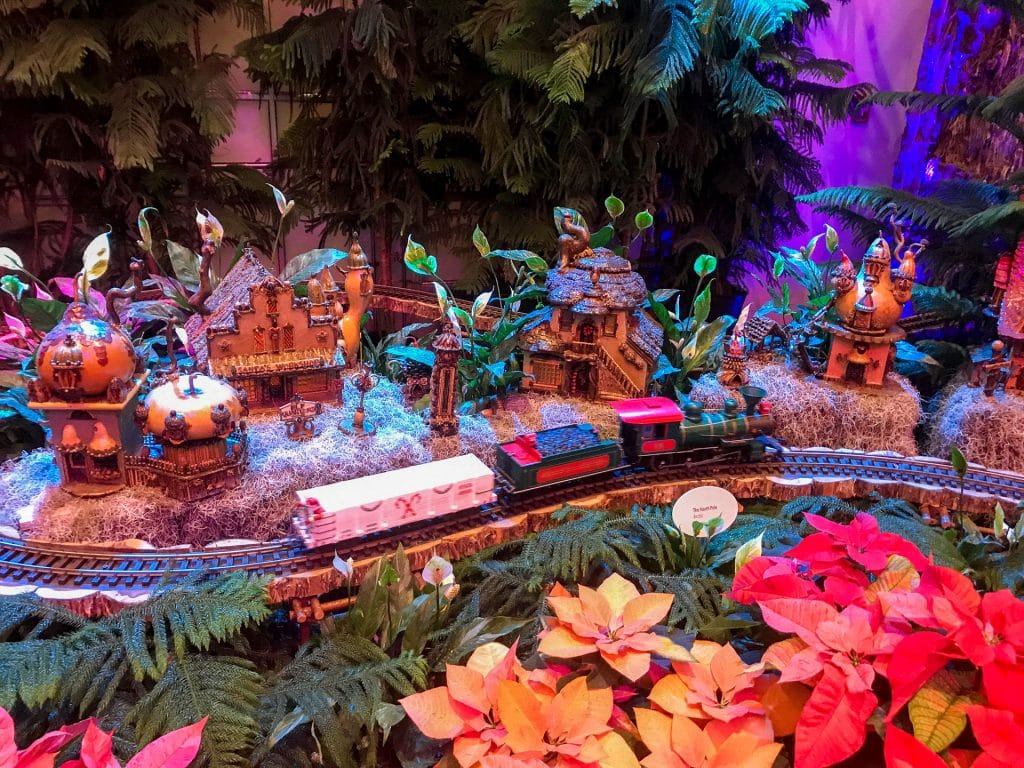 A train model passing through a colorful town at Washington D.C.'s National Botanical Garden during Seasons Greenings - one of the best things to do in Washington D.C. in the winter.