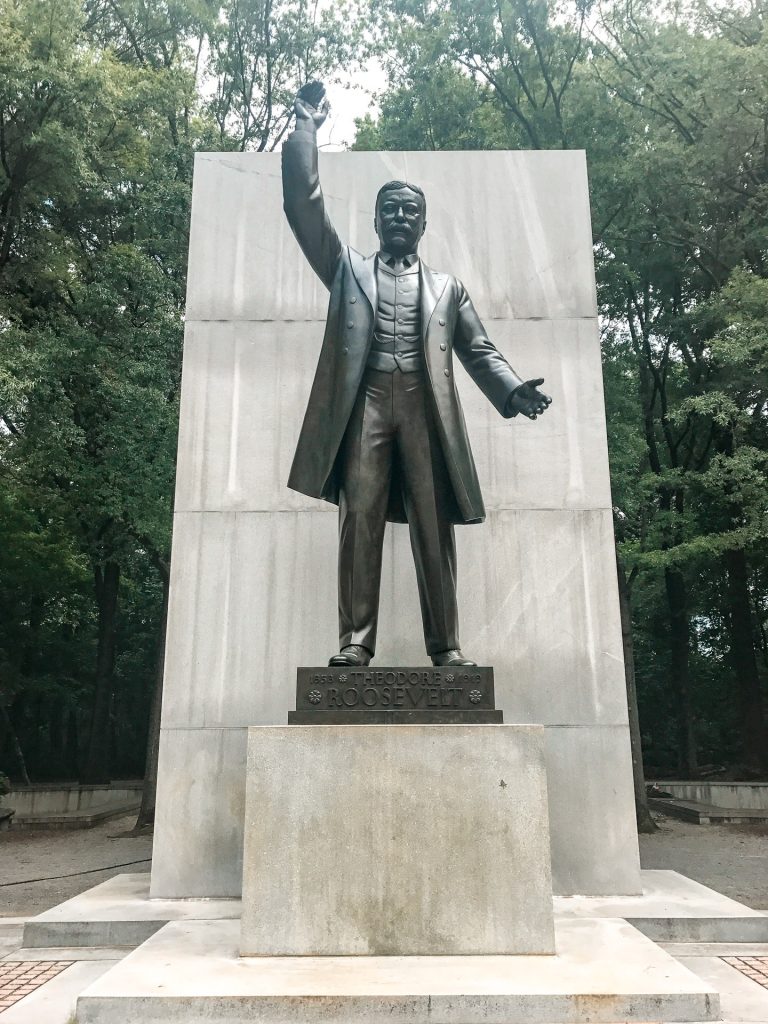 A statue of Theodore Roosevelt raising his hand as a memorial