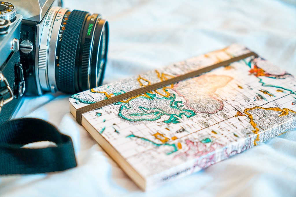 A notebook with the map as the cover and a camera next to it. 