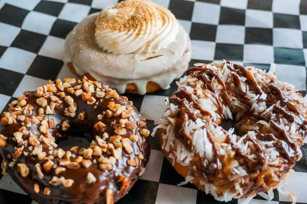 A picture of some of the best donuts in Dallas from The Donut Kitchen. A Texas Sheet Cake, Key Lime, and Caramel Coconut donut.
