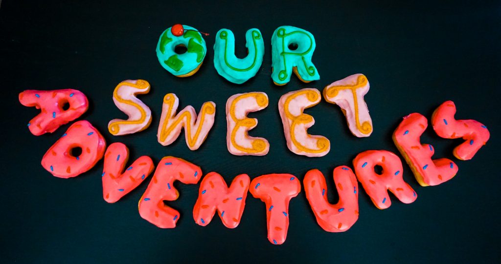 Donuts that spell out "Our Sweet Adventures". 