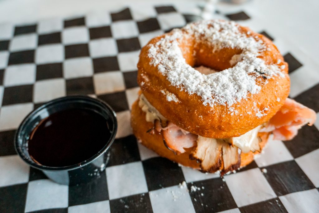 A Monte Cristo donut sandwich with a side of raspberry sauce from The Donut Kitchen.