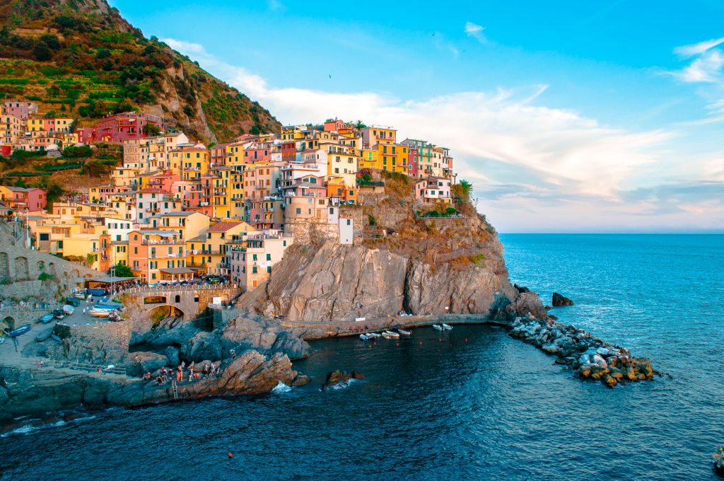 The sun hitting the colorful houses along the cliff - this city is known as Cinque Terre in Italy and a must see for anyone's Italy bucket list.