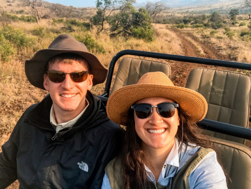 A man and woman riding a jeep enjoying their African safari.