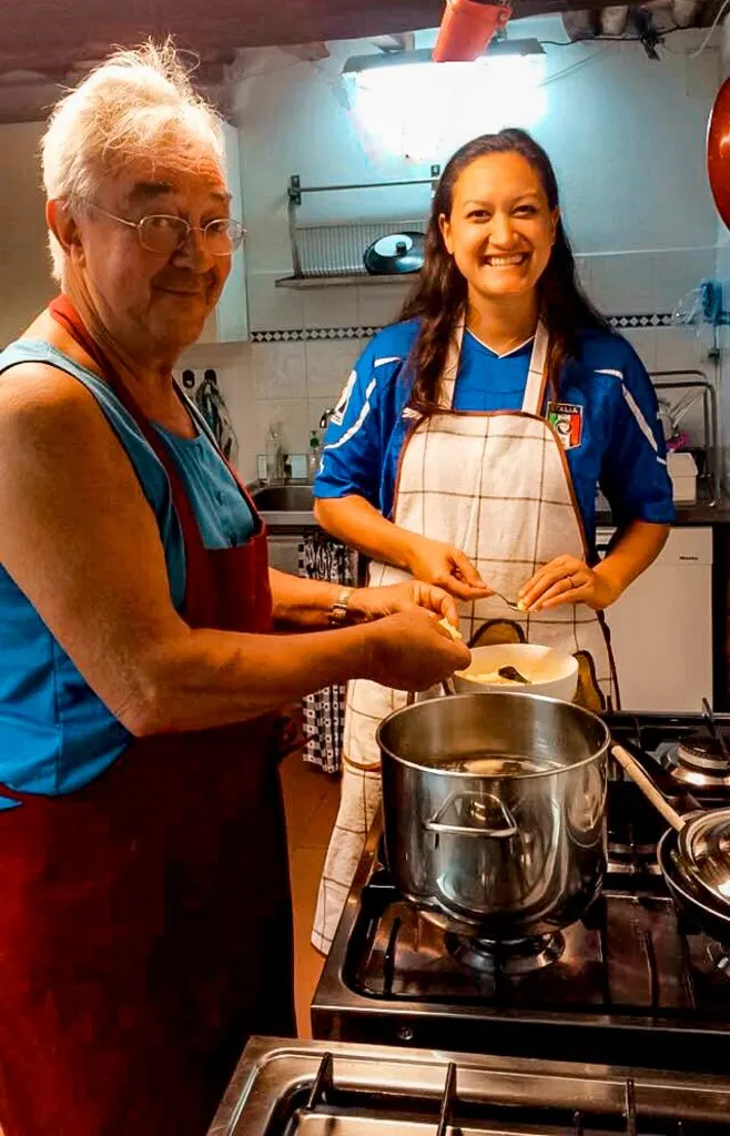A young woman learning how to cook with her Italian host.