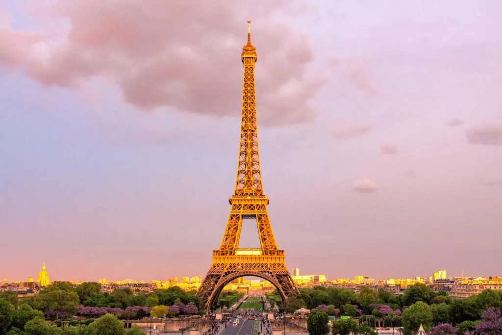 The Eiffel Tower with the golden sun shining on it in Paris, France - one of the most romantic babymoon destinations in the world. 