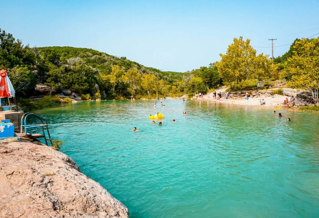 People swimming at Blue Hole Pool at Turner Falls Park in Oklahoma.