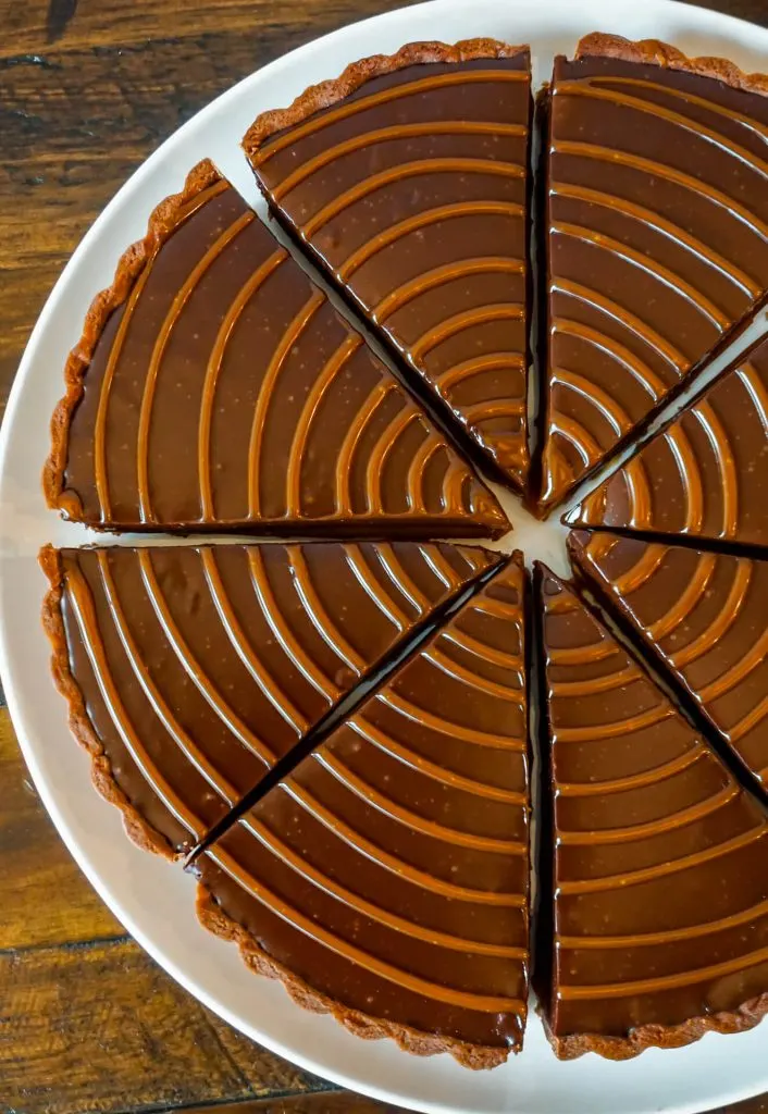 Zoomed in photo of chocolate caramel tart slices with caramel drizzled on top.
