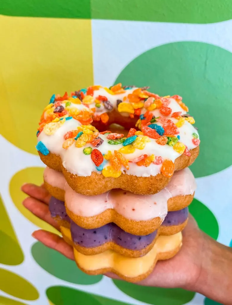 A stack of mochi donuts (chewy puffs) from Fat Straws Bubble Teas. Flavors shown in the picture are Fruity Pebbles, strawberry, blueberry, and passion fruit.