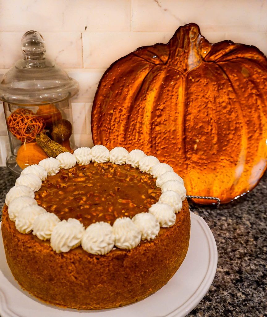 a whole 9 inch Pumpkin Pecan Cheesecake with graham, cracker crust on the entire sides, pecan caramel and whipped cream on top.