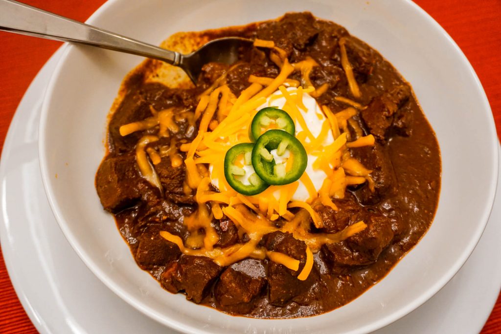 A bowl of Texas Chili with a spoon in it. 