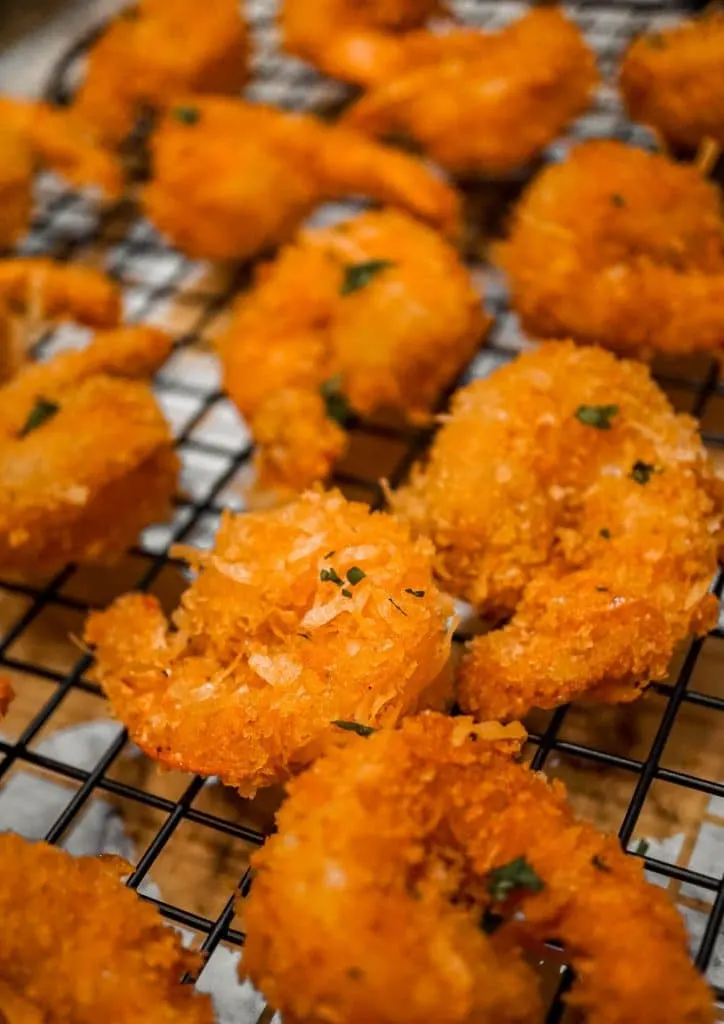 Coconut shrimp laying on a cooling rack.