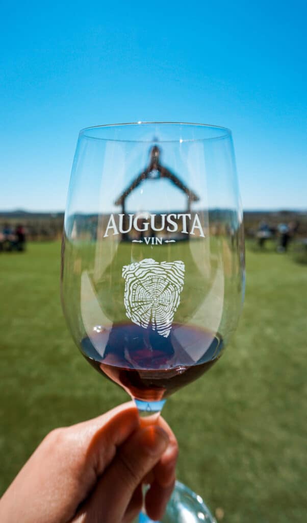 A monogrammed glass of wine with red wine from Augusta Vin Winery - one of the best wineries in Fredericksburg.