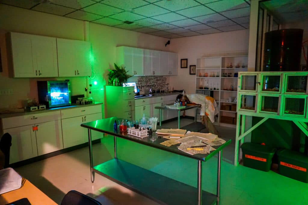 The inside of an escape room themed The Apocalypse Room at The Silver Spur Resort. The room resembles a scene lab and has a fake dead scientist.
