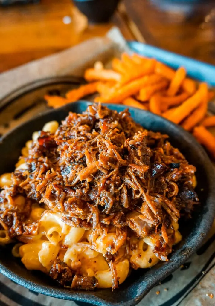 A skillet of Mac-n-cheese loaded with chopped brisket on top from the Q & Brew Restaurant.