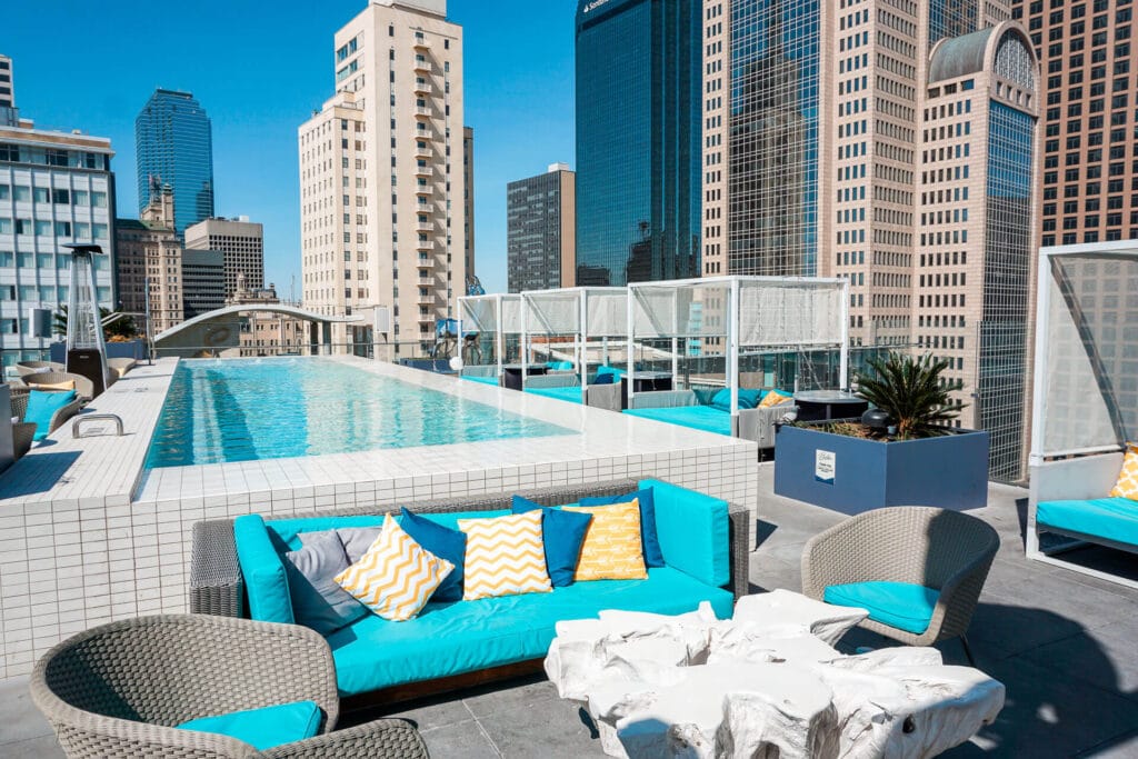 A rooftop pool at The Statler Hotel in Dallas with downtown Dallas views and cabanas.