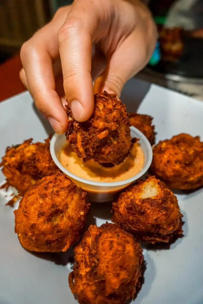 A hand dunking "coyote balls" into spicy ranch from Loco Coyote in Glen Rose, Texas.