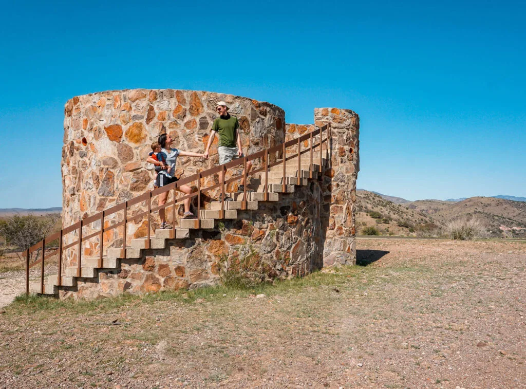 A couple with a baby walking up stairs on the CCC fort at Davis Mountains State Park.