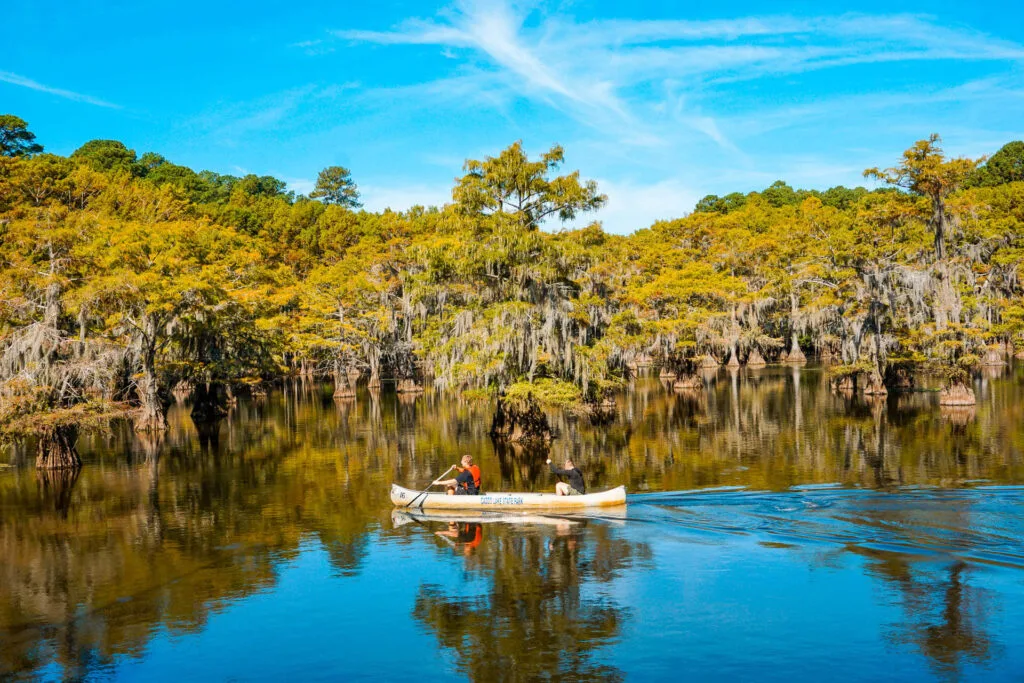 Two guys paddling on a canoe on Caddo Lake - one of the best things to do.