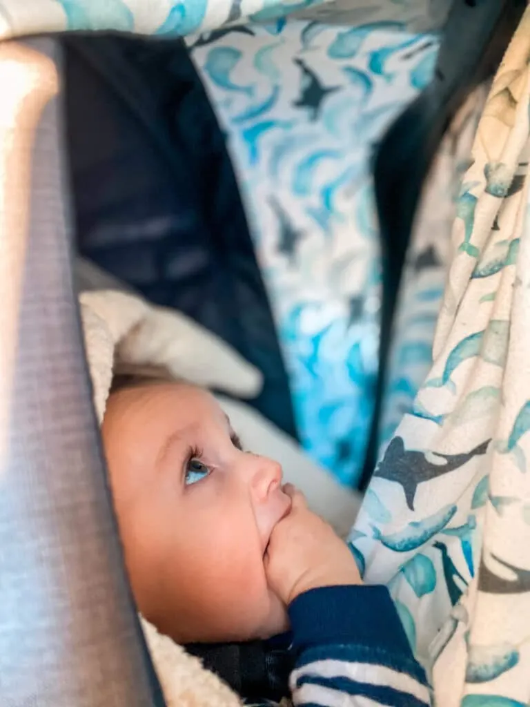 Road tripping with a baby in his car seat looking up at the patterns on his blanket.
