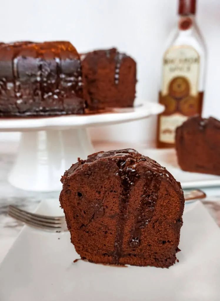 A slice of Chocolate Rum Cake with a chocolate rum syrup drooping down the sides.