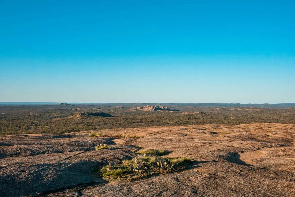 Panoramic views of the Texas Hill Country from the summit of Enchanted Rock - one of the best things to do in Fredericksburg 