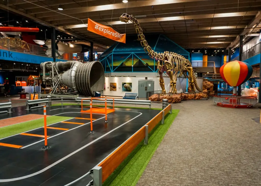 Ground floor of the Science Museum Oklahoma with a segway park and giant dinosaur.