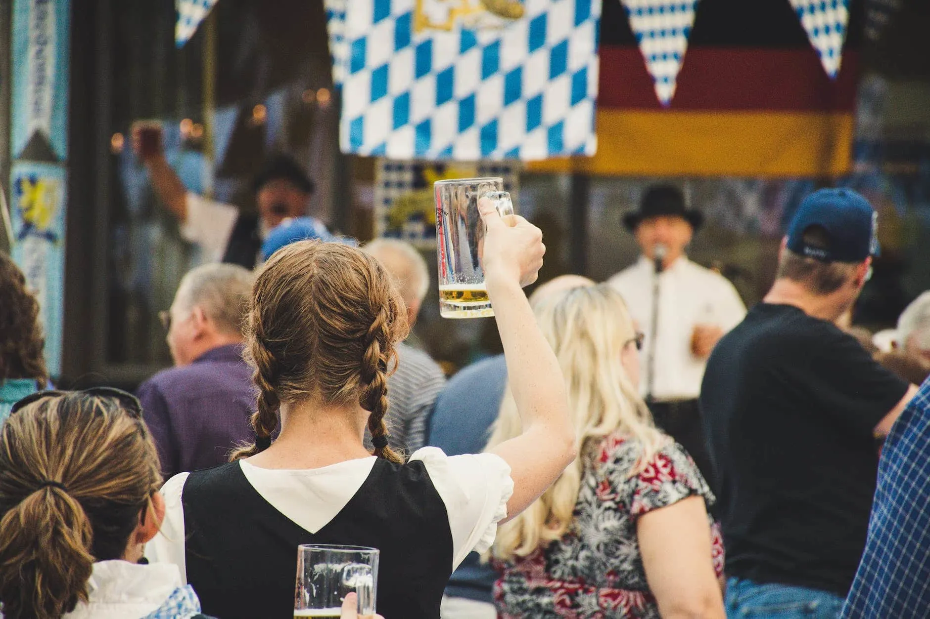 woman standing in a crowd holding up beer glass