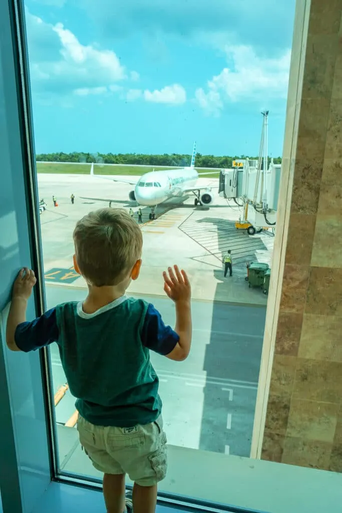 Toddler looking at an airplane (a guide for the best travel toys for toddlers).
