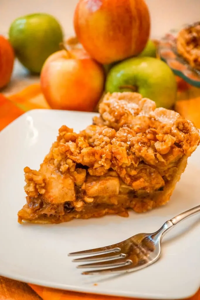 A slice of Caramel Apple Walnut Pie with a Streusel Topping next to a fork.