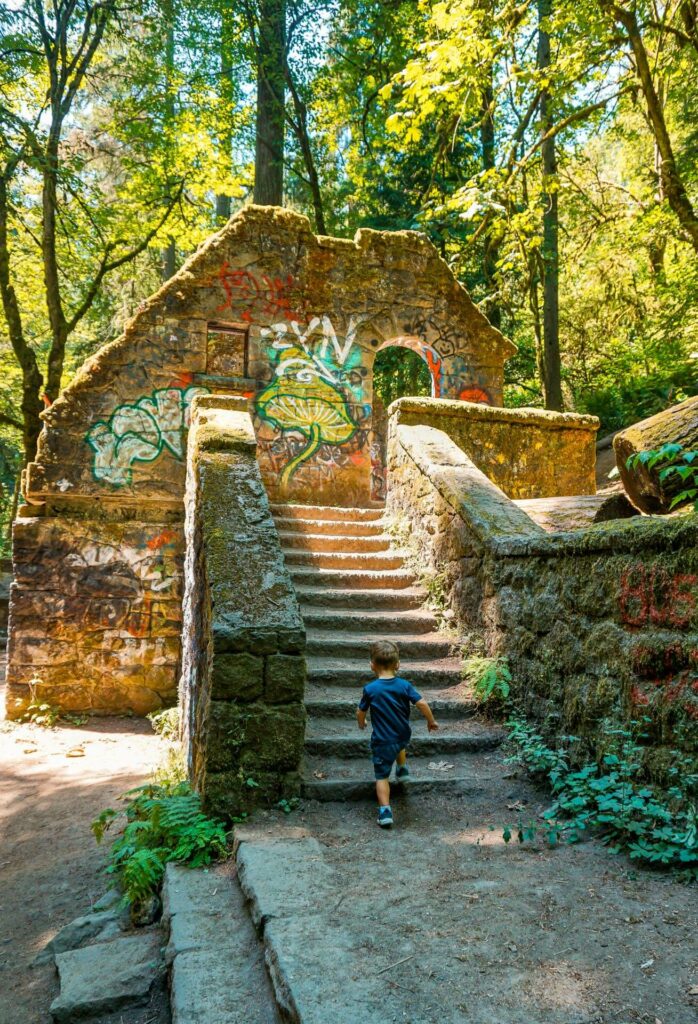 A boy walking up stairs at the Witch's Castle (stone house) in Forest Park, Portland. 
