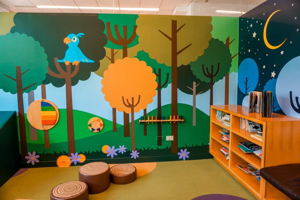 A wall mural of trees and a bird at the Dallas Museum of Art Arturo's Nest - an area for toddlers.