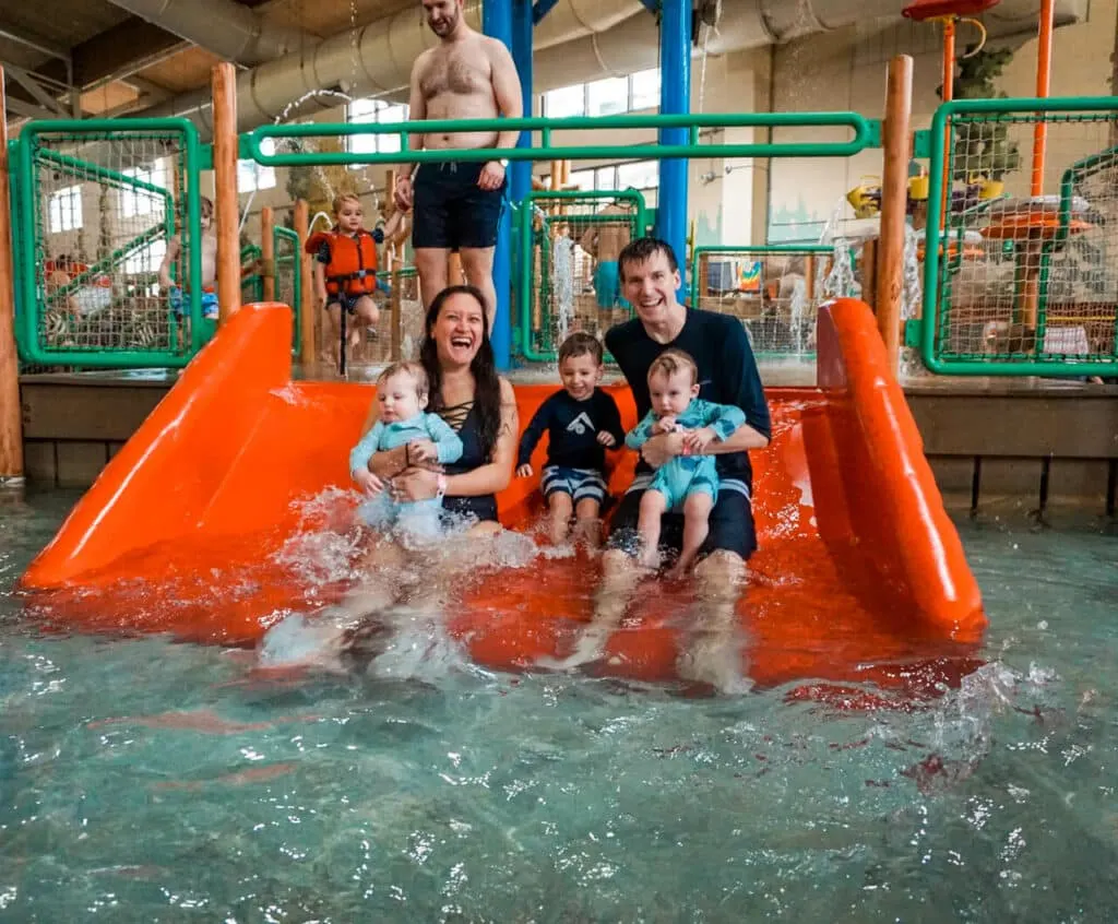 A family of five going down the water slide at Great Wolf Lodge indoor water park.