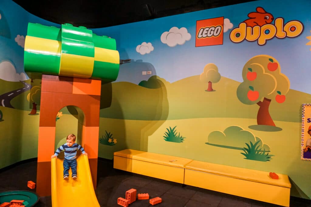 A toddler going down a lego slide at the DUPLO village inside Legoland Discovery Center in Dallas, Texas.