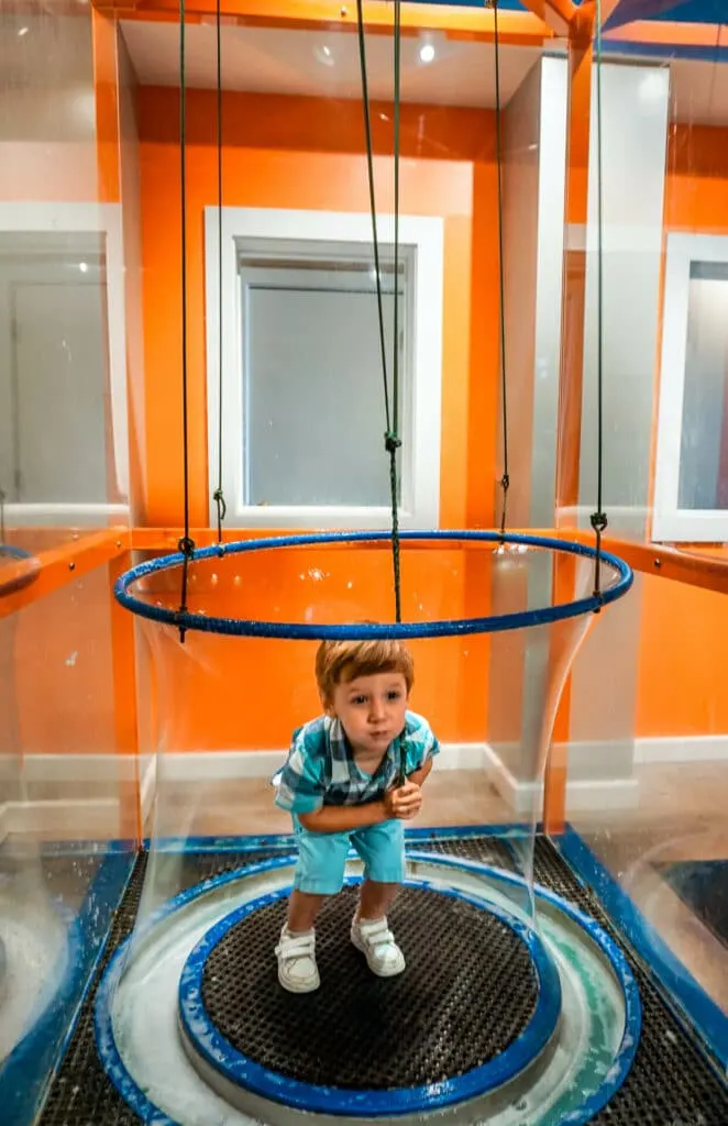 A boy enclosed in a giant bubble at the Magic House - one of the best things to do in St. Louis with toddlers.