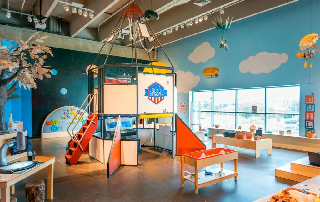 A rocket ship and sensory tables at the Discovery Room inside the Saint Louis Science Center - one of the best things to do in St. Louis with toddlers.