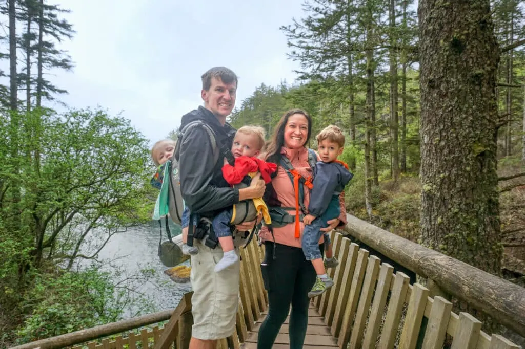 A family with three boys in hiking carriers at Cape Flattery. 