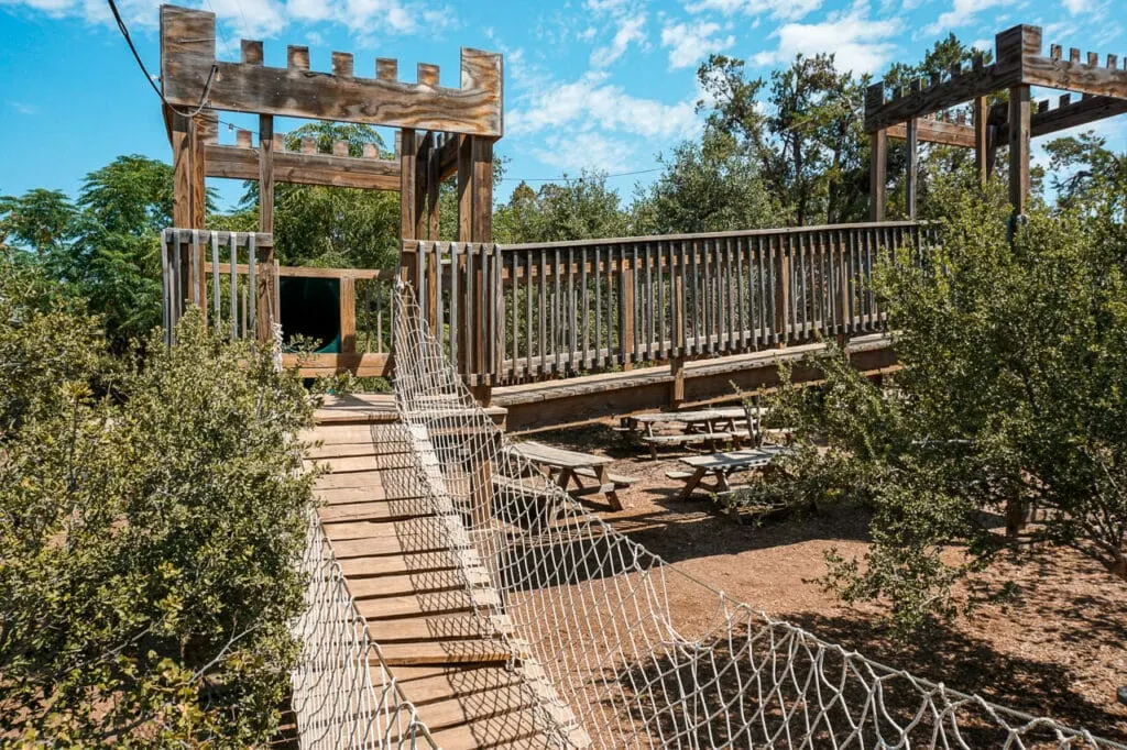 A wooden fort with a rope bridge from 12 Fox Beer Co. - one of the best kid-friendly breweries in Dripping Springs.