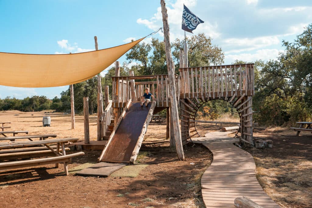 A wooden playground fort at Jester King Brewery - one of the best kid-friendly breweries in Dripping Springs.
