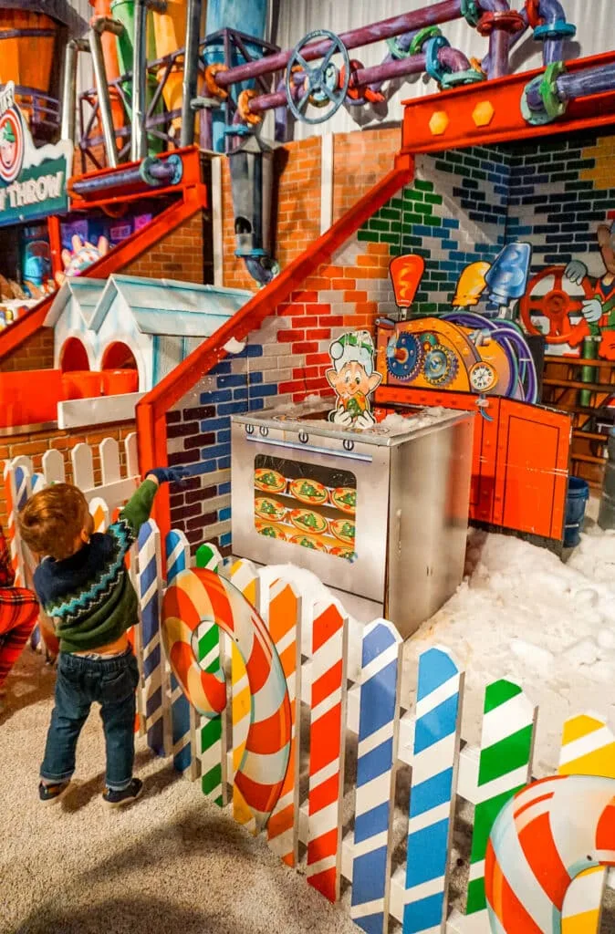 A toddler boy throwing real snow at elves inside the Gaylord Texan Resort.